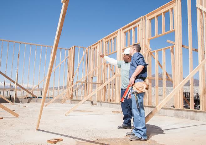 Construction crew reviewing framing on a job site